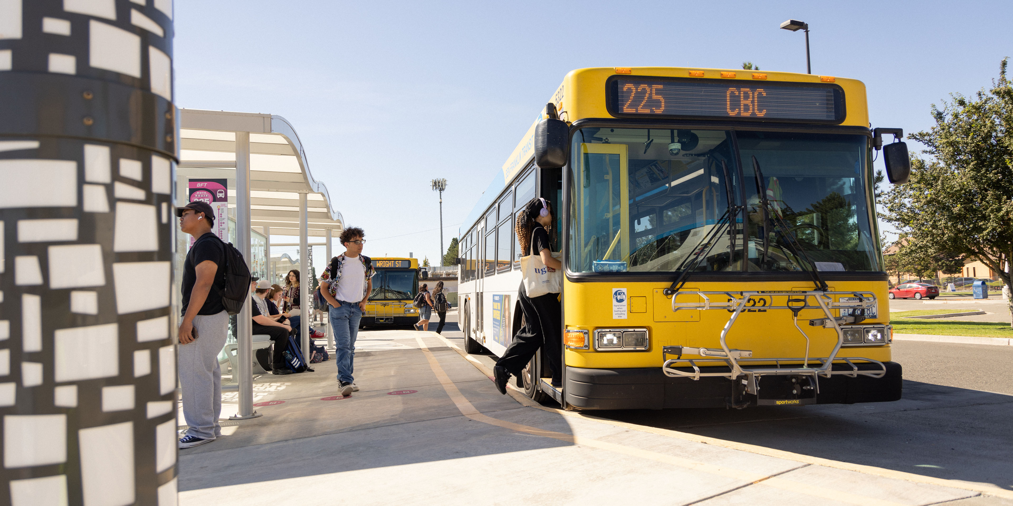Image of a bus stopped at a bus stop.